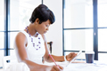 Young woman sitting at a desk in an office and working on blueprint - PhotoDune Item for Sale