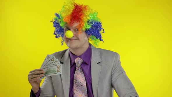 Clown Businessman Entrepreneur Boss in Wig Waves with Money Banknotes. Halloween