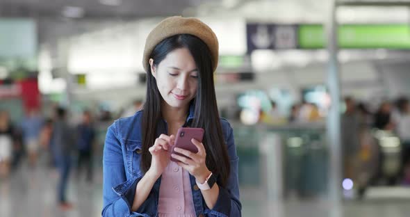 Woman search on mobile phone in the station