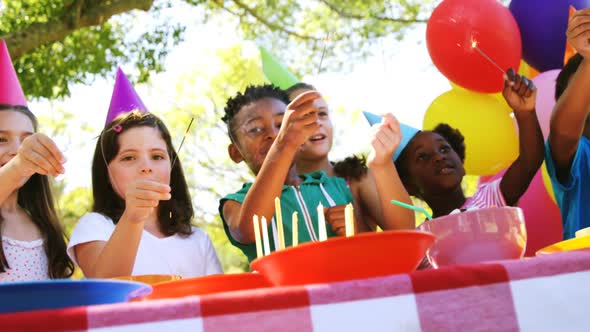 Group of kids playing with sparkler while celebrating a birthday alt