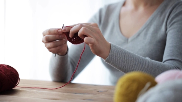 Woman Knitting With Crochet Hook And Red Yarn