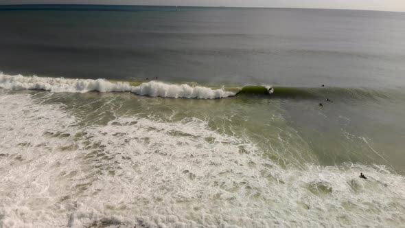 Epic drone tracking shot of surfer riding a wave.