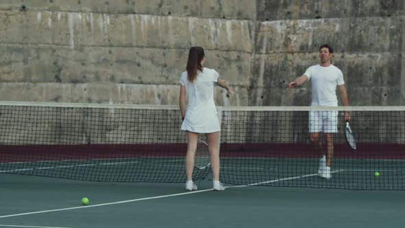 Woman and man playing tennis on a court