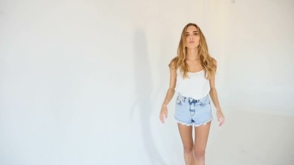 Young Model Girl In White Tank Top And Short Blue Jean Shorts