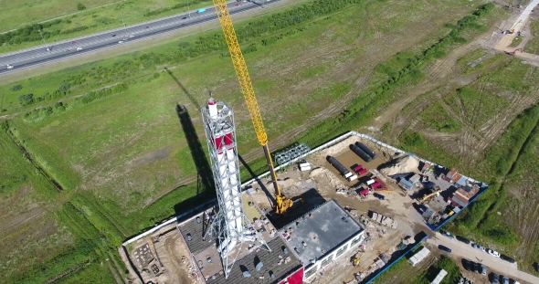 Chimney Pipe Construction Aerial, The Crane Lifts The Pipe Segment Flying Around