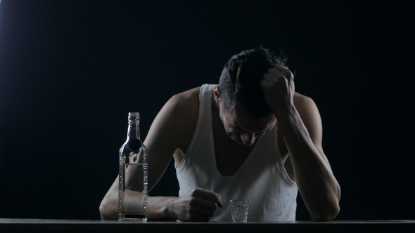 Depressed Man Crying With a Bottle Of Vodka. Man In Despair