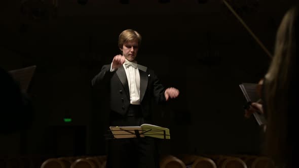 leader of the symphony orchestra. Young conductor leads the orchestra