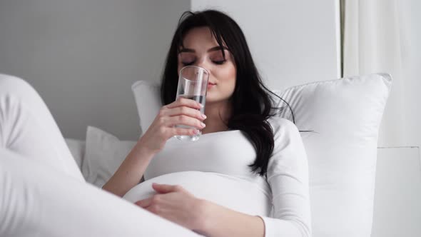 Drink Water. Pregnant Woman Drinking Water From Glass At Home