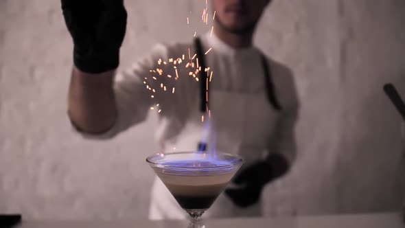 Bartender Sprinkling Cinnamon Powder Over Irish Cream Cocktail on Fire