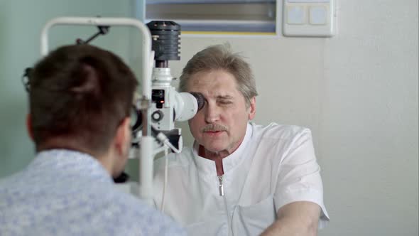 Ophthalmologist and Young Man Checking Eyesight in Clinic