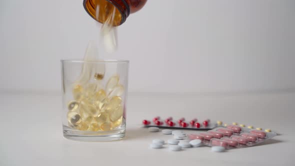 Liquid gel capsules are sprinkled into a glass out of the jar.