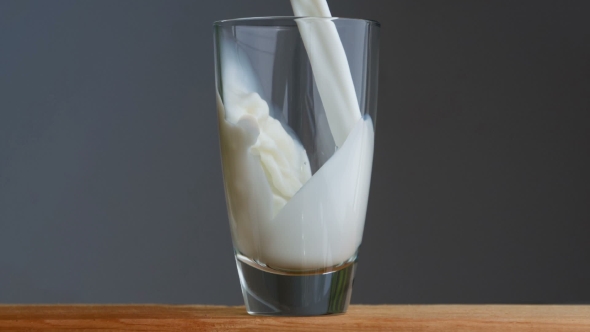 Milk Being Poured On a Grey Background.