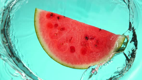 Super Slow Motion Shot of Falling Fresh Watermelon Slice Into Water at 1000Fps.