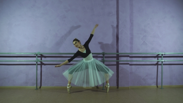Wearing Pointe Shoes Ballerina Dances Near Barre In Dancing Hall