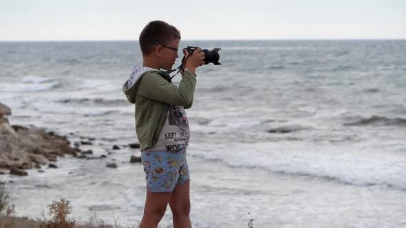 Beach Summer Vacation. Boy on the Beach with a Camera