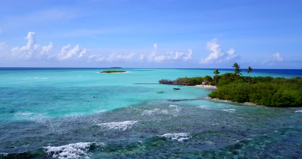 Daytime flying copy space shot of a white sandy paradise beach and blue sea background 