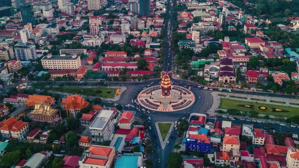 Independence Monument Illuminated At Sunset With Vehicles Driving At Intersection Of Norodom And Sih