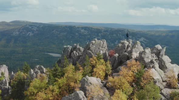 Man Stands on the Peak of a Mountain Above the World