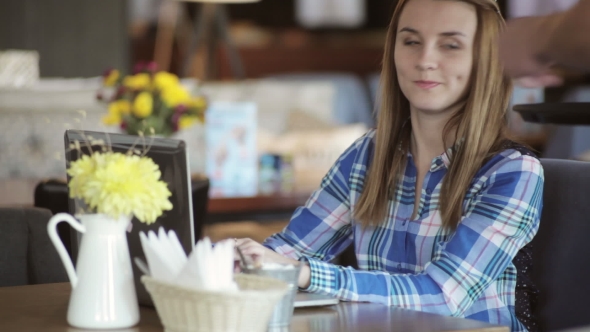Young Pretty Woman With Laptop Gets Coffee From Waiter In Cafe
