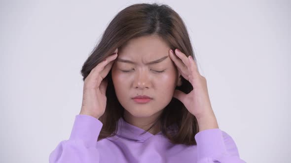 Face of Young Stressed Asian Woman Having Headache