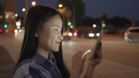 Young Asian Woman Using Digital Tablet Screen in the City alt