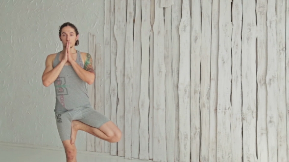 Young Sporty Man Practicing Yoga In Fitness Studio