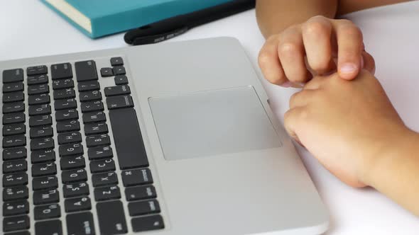 A child girl on distance learning sits in front of a laptop and does homework. Distance learning