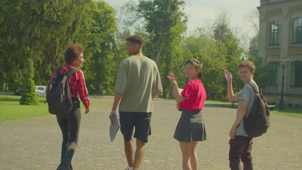 Group of Cheerful Diverse Multiracial Students Waving Goodbye to Classmates