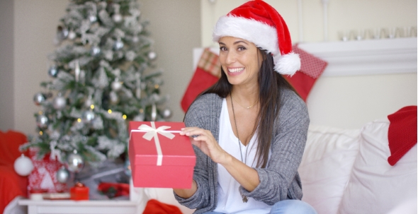 Excited Young Woman Opening a Christmas Gift