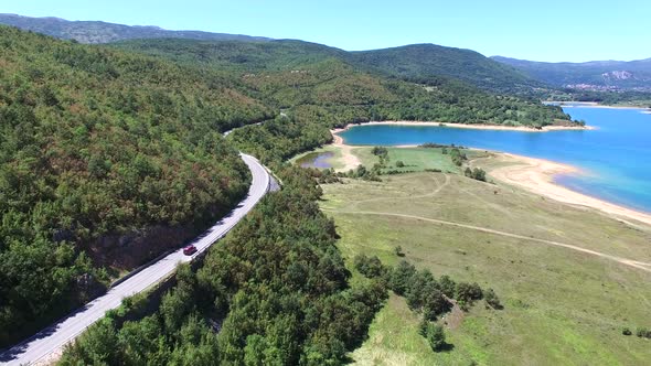 Aerial view of red van driving by artificial lake Peruca, Croatia