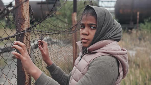 Portrait of Refugee Girl at Barbed Wire Fence