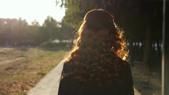 Pretty Lady Turns Back Shaking Hair Walking Along Park Road