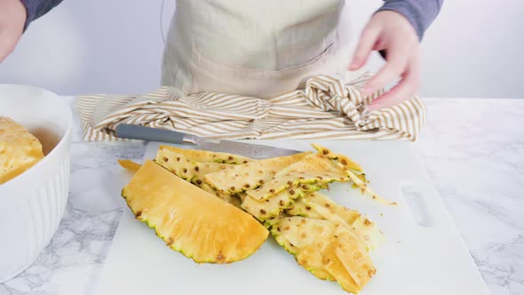 Step by step. Cutting pineapple on a white cutting board