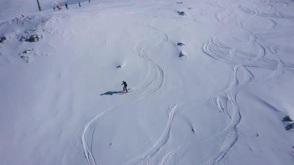 Aerial view of people skiing among the pine trees in Switzerland.