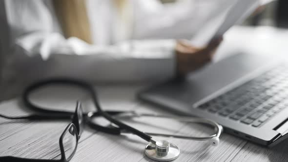 Close Up of a Doctor is Working and Typing on Laptop in a Clinic