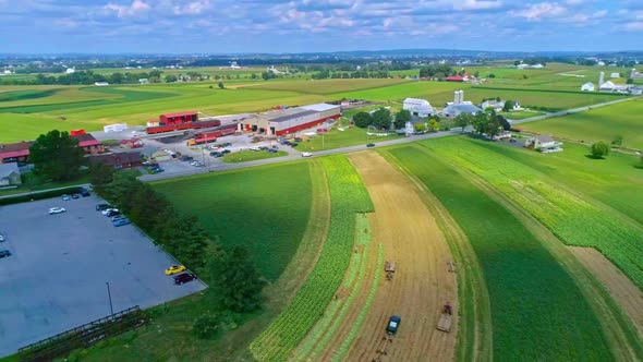 Aerial Traveling View of Corn Fields and Harvesting Crops, With a Train Yard