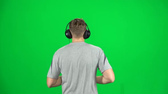 Guy in Big Headphones Is Running, Chroma Key. Back View. Slow Motion