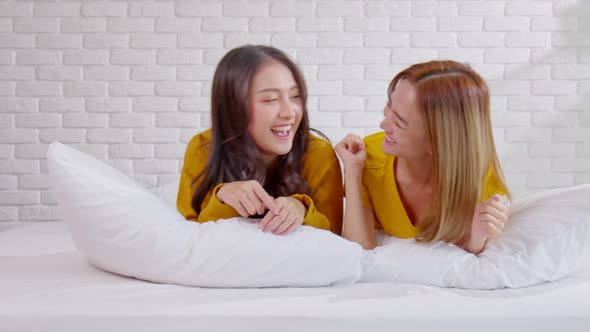 Beautiful two female LGBT lesbian embracing and looking together with love and romance on bed