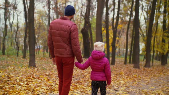 Positive Father and Daughter Relaxing in Autumn Forest