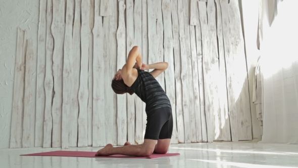 Young Sporty Man Practicing Yoga In Fitness Studio