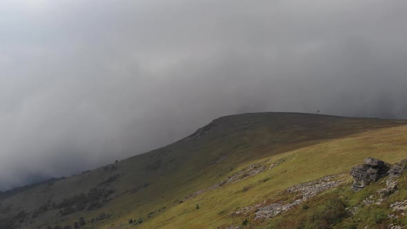 Aerial shot om mountains top covering by cloud 4K