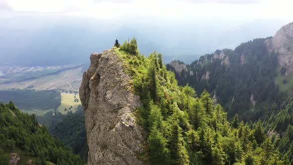 Man On The Crest Of A Rock In The Mountains