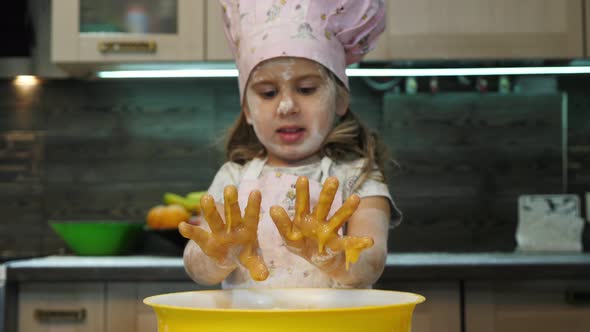 Girl with messy hands playing in the kitchen