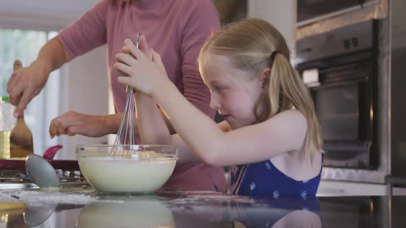 Side view of Caucasian girl cooking with her mother at home