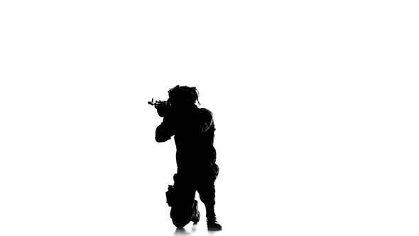 Soldier Stands on One Knee and Aiming a Gun. Silhouette