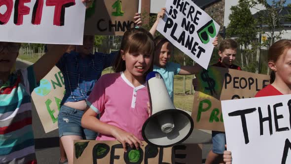 Group of kids with climate change signs and megaphone in a protest