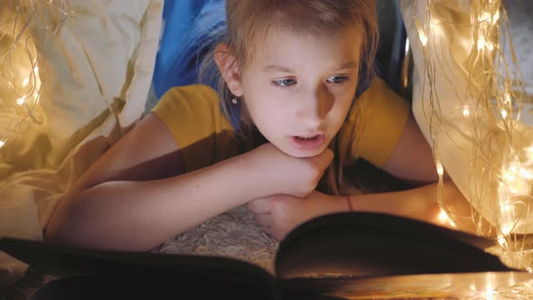 Family Bedtime Pretty Girl Reading Book in a Tent House at Night