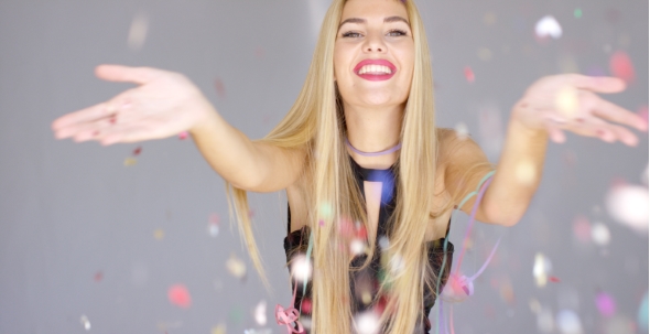 Sexy, Blond Girl Blowing Confetti To Camera Direction
