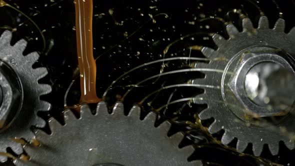 Super Slow Motion Detail Shot of Gear Mechanism and Oil on Dark Background at 1000 Fps