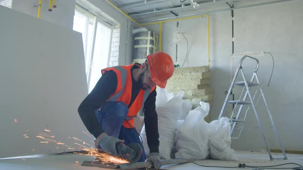 Male Builder Cutting Metal Detail During Work